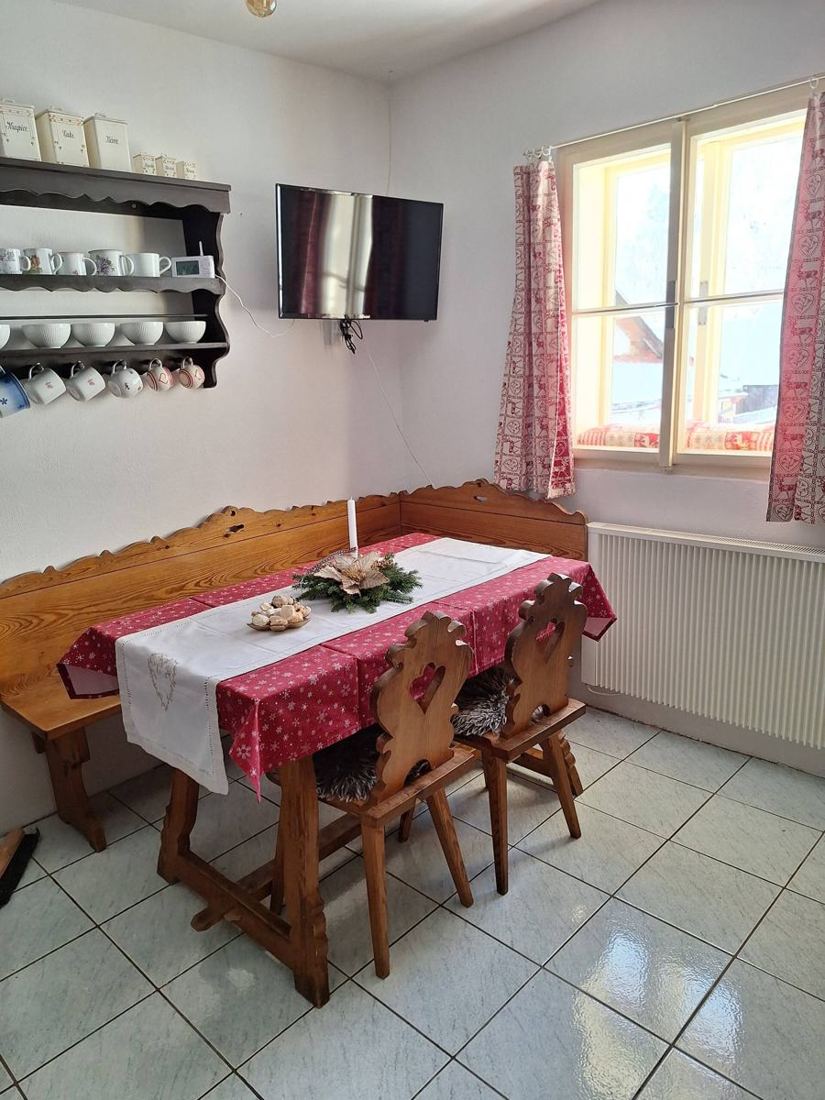 Rohová lavice se stolem a malovanými židlemi